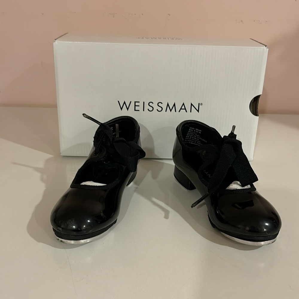 Little girl’s black patent leather tap shoes.
